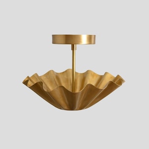 May include: A gold-toned ceiling light fixture with a ruffled, scalloped shade.