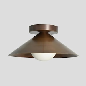 May include: A bronze ceiling light fitting featuring a conical shade and a white spherical bulb. The fixture has a circular base and a modern design, suitable for interior lighting, with a diameter of approximately 30 cm.