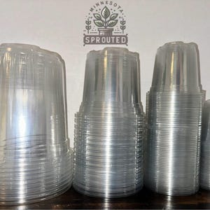 May include: A stack of clear plastic cups, likely for planting, with the text "Minnesota Sprouted" on the background.