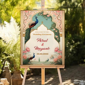 May include: A wedding ceremony sign on an easel. The sign features a peacock design with the names "Parul & Mayank" and the date 26.05.2025. The sign has a floral and peacock design with the words "Welcome to the Wedding Ceremony".