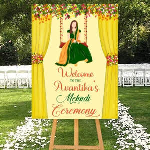 Puede incluir: Un cartel de bienvenida amarillo y verde para una ceremonia de Mehndi. El cartel presenta a una mujer con un atuendo verde y naranja sentada en un columpio decorado con flores. El texto en el cartel dice "Bienvenido a la ceremonia de Mehndi de Avantika".