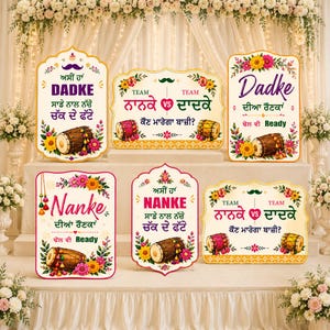 May include: A collection of decorative signs with floral and drum designs. The signs feature text in a foreign language, with phrases like "Dadke" and "Nanke". The signs are decorated with flowers and drums.