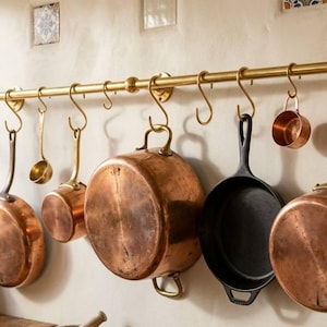 Könnte beinhalten: Ein Set aus drei Keramikbechern mit gesprenkelter, matter Oberfläche. Die Becher sind in Creme-, Hellgrau- und Dunkelgrautönen gehalten. Jeder Becher hat ein schlichtes, minimalistisches Design.