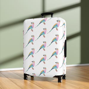 May include: White luggage cover with a repeating pattern of colorful watercolor birds. The birds are pink, blue, green, and yellow.
