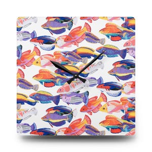 May include: Square wall clock with a white background and a colorful fish pattern. The fish are in shades of red, orange, yellow, blue, purple, and white. Black clock hands indicate the time.
