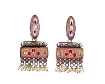 May include: Pink and silver dangle earrings with a floral design and pearl accents.