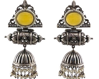 May include: A pair of silver earrings with yellow stone accents. The earrings feature a bell-shaped dangle with a pearl drop.