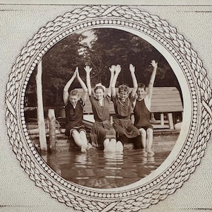 Cartão postal de 1910 com crianças brincando às margens de um lago.