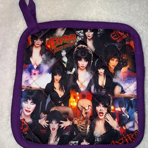 Puede incluir: Un agarrador de cocina acolchado cuadrado con un borde de tela morada y un lazo para colgar. La superficie presenta un collage de imágenes de Elvira, Mistress of the Dark, con el texto Elvira's House of Horrors y Elvira Mistress of the Dark.