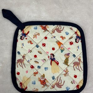 Puede incluir: Salvamanteles cuadrado acolchado con borde y lazo azul marino. La tela color crema presenta un estampado de Blancanieves y los Siete Enanitos, ciervos y otros elementos de cuento de hadas. Diseñado para uso en la cocina.