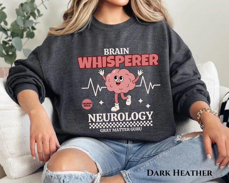 May include: Dark heather grey sweatshirt with a brain graphic and the text "Brain Whisperer Neurology Gray Matter Guru".