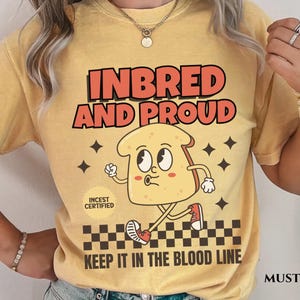 May include: A yellow t-shirt with the text "Inbred and Proud" and a cartoon image of a slice of bread with legs and arms. The bread is wearing a red shoe and has a red circle with the text "Incest Certified" on it. The text "Keep it in the blood line" is printed below the image.