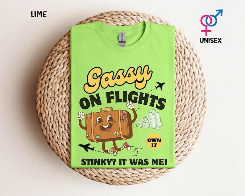 May include: Lime green unisex t-shirt with the text "Gassy on Flights" and a cartoon suitcase graphic. The suitcase has a smiling face and is running with a cloud of gas behind it. The text "Stinky? It was me!" is below the graphic.