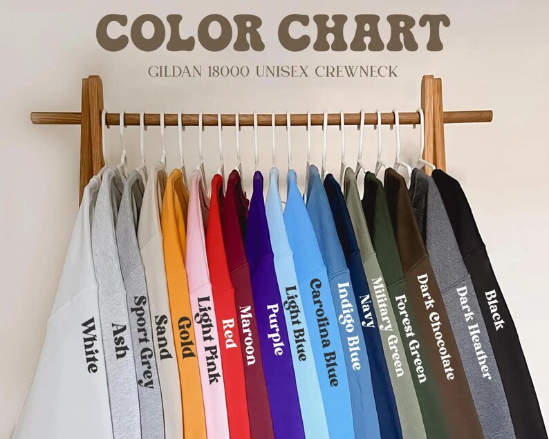 May include: Color chart showing 15 different colors of Gildan 18000 unisex crewneck sweatshirts. The colors are: White, Ash, Sport Grey, Sand, Gold, Light Pink, Red, Maroon, Purple, Light Blue, Carolina Blue, Indigo Blue, Navy, Military Green, Forest Green, Dark Chocolate, Dark Heather, and Black.