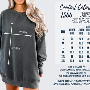 May include: A dark gray unisex garment-dyed sweatshirt with a size chart. The chart lists measurements in inches for width, length, and sleeve length. The sweatshirt is 80% ring-spun cotton and 20% polyester.