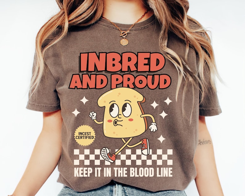 May include: A brown t-shirt with the text "INBRED AND PROUD" in red and orange letters. A cartoon bread character with a face and legs is walking on a checkered pattern with the text "KEEP IT IN THE BLOOD LINE". A small red circle with the text "INCEST CERTIFIED" is in the upper left corner.