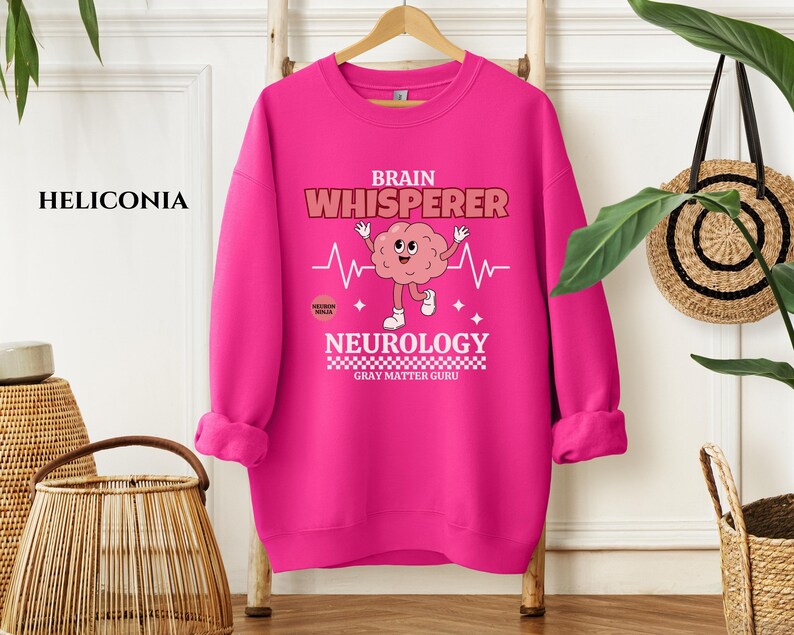 May include: A pink sweatshirt with a brain graphic and the text "Brain Whisperer Neurology Gray Matter Guru".