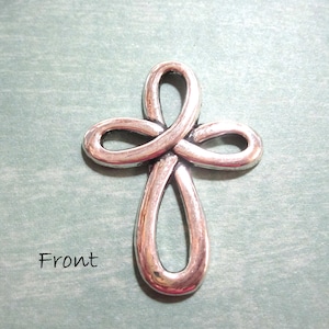 May include: Silver-toned metal cross pendant with a knotted design. The cross is a simple, elegant design with a smooth finish.