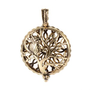 May include: Gold-toned metal pendant featuring an owl perched on a tree branch with intricate filigree details. The pendant is round and has a delicate, openwork design.