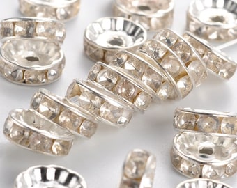 May include: Silver-toned metal bead rings with clear rhinestones. The rings are stacked on top of each other, creating a spiral effect.
