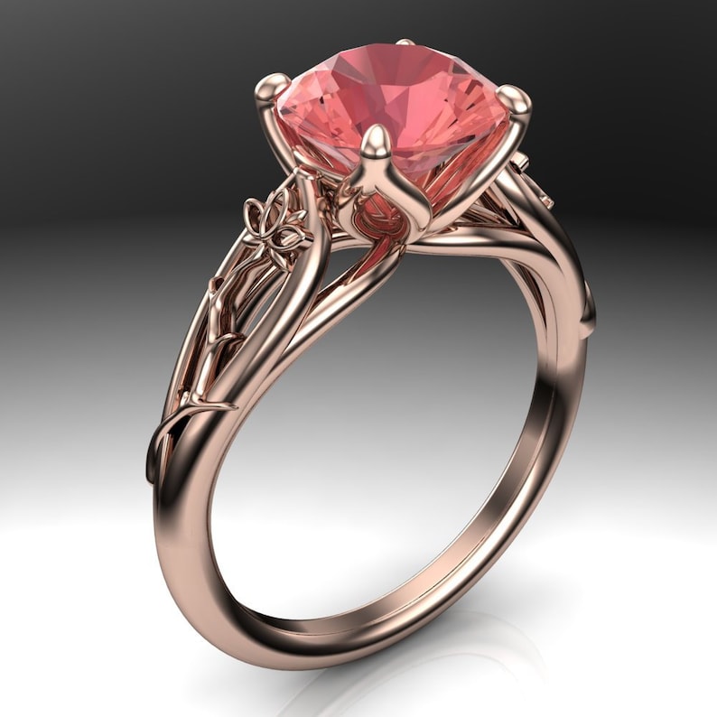 Puede incluir: Un anillo de oro rosa con un delicado dise&ntilde;o floral y una gran piedra preciosa rosa en el centro.
