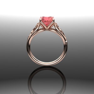 Puede incluir: Un anillo de compromiso de oro rosa con una piedra preciosa rosa en forma de coraz&oacute;n y detalles florales intrincados.