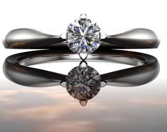 May include: A silver engagement ring with a round, clear diamond set in a four-prong setting.