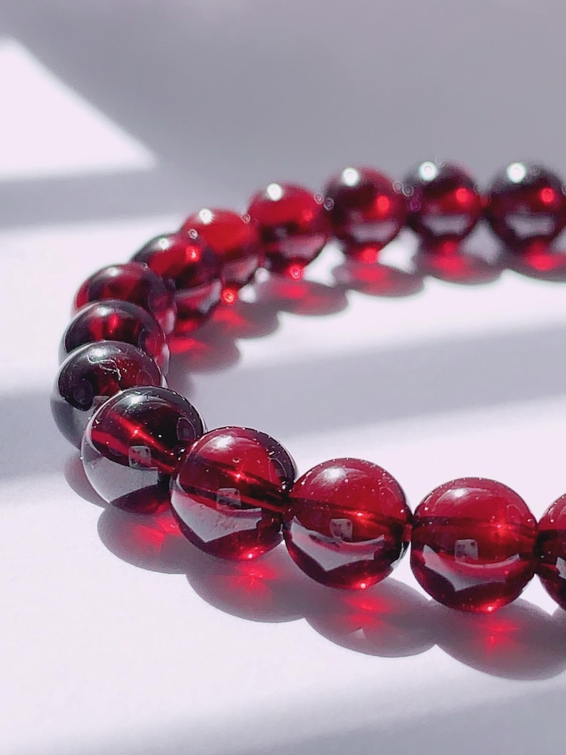 Puede incluir: Un brazalete de piedras preciosas rojas con cuentas redondas. El brazalete est&aacute; hecho de piedras naturales y es una hermosa joya.