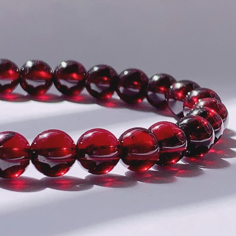 Puede incluir: Un brazalete de piedras preciosas rojas hecho de cuentas redondas. El brazalete est&aacute; hecho de piedras naturales y es una opci&oacute;n popular para joyer&iacute;a.