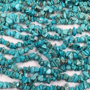 May include: A strand of turquoise chip beads. The beads are a light blue color with brown markings. The beads are irregular in shape and size.