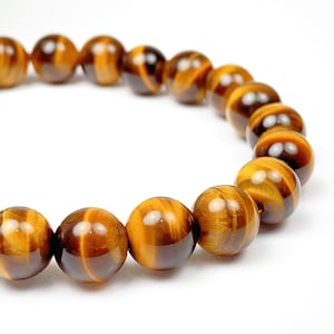 May include: A brown tiger's eye gemstone bracelet with round beads.