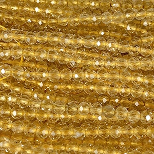 Puede incluir: Una hebra de cuentas de citrino facetadas, cada cuenta es de color amarillo dorado claro y tiene una forma redonda facetada.