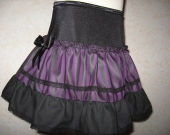 May include: A black and purple striped skirt with a black waistband and a black bow. The skirt has multiple layers of ruffles.