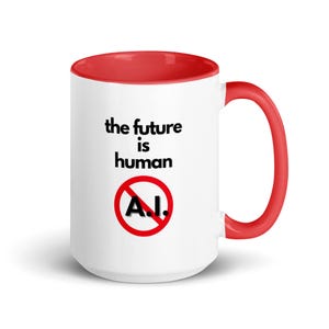 May include: White ceramic mug with a red rim and handle. The mug has a black graphic that says "the future is human" with a red circle and diagonal line through the letters "A.I."