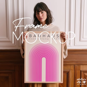 Puede incluir: Una impresión artística enmarcada con un diseño de arco rosa y el texto "BAUHAUS Ausstellung 1923". La obra de arte está en un marco de madera clara. La imagen también incluye el texto "Frame Mockup".