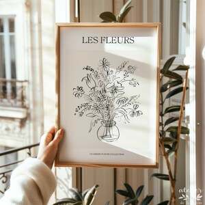 Pu&ograve; includere: Un disegno in bianco e nero di un mazzo di fiori in un vaso. Il disegno &egrave; su sfondo bianco con il testo "LES FLEURS" e "LE JARDIN FLEURS COLLECTION" in nero.