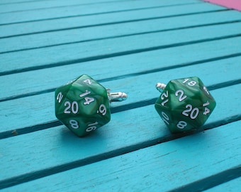 May include: A pair of green 20-sided dice cufflinks. The dice are green with white numbers and a marbled pattern.