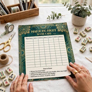 Puede incluir: Una tarjeta de puntuación rectangular para noches de Mahjong con un borde de plumas de pavo real en azul cerceta y dorado. La tarjeta incluye una cuadrícula para nombres de jugadores y seis juegos, con instrucciones de puntuación. Texto Mahjong Night Score Card.