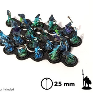 May include: A set of 20 black plastic bases for miniature figures. Each base is 25 mm in diameter and features a textured surface. The bases are arranged in a curved pattern and are ideal for displaying or storing miniature figures.