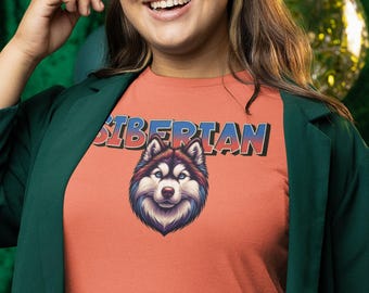 Puede incluir: Una camiseta de color naranja coral con la palabra "SIBERIAN" en letras azules, rojas y blancas. Un husky siberiano de dibujos animados con ojos azules está centrado en la camiseta.