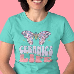 May include: A turquoise t-shirt with a pink and purple butterfly graphic and the text "Ceramics Life" in a retro font.