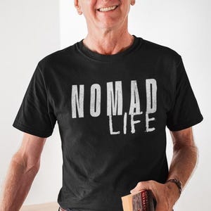 May include: Black crew neck t-shirt with the white text "NOMAD LIFE". The shirt is made of a soft material. The shirt is a casual wear item.