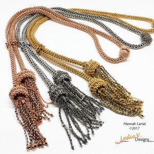 May include: Four beaded necklaces with tassels in gold, silver, and rose gold. Each necklace has a knotted tassel at the end. The necklaces are arranged in a fan shape on a white background. The text "Hannah Lariat ©2017 Leslie V. Designs" is at the bottom of the image.