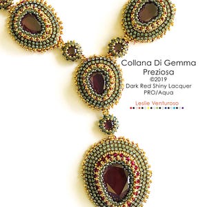 Könnte beinhalten: Eine Perlenkette mit einem großen, tropfenförmigen Anhänger, der mit einem dunkelroten Edelstein besetzt ist. Die Kette ist aus goldenen, grünen und roten Perlen gefertigt. Der Text "Collana Di Gemma Preziosa ©2019 Dark Red Shiny Lacquer PRO/Aqua Leslie Venturoso" ist unter dem Anhänger gedruckt.
