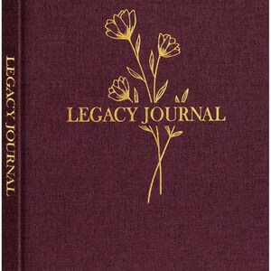 May include: A burgundy Legacy Journal with gold foil lettering and floral design. The journal's cover features the words "LEGACY JOURNAL" and a delicate floral illustration. The spine also has the words "LEGACY JOURNAL" printed vertically.