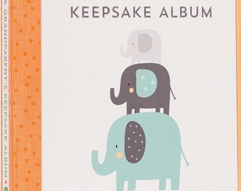 May include: A keepsake album with the text "A Grandparent's Keepsake Album." The cover features three stacked elephants in gray and blue, with the text "Special Memories of My Grandchild's First Years."