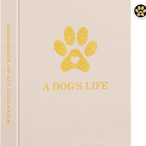 Op de afbeelding: Een beige notitieboek met gouden letters en een pootafdrukontwerp. De cover leest "A Dog's Life" en "Memories of My Dog Ever". De pootafdruk heeft een hartvormige uitsparing. De onderkant van het notitieboek leest "Life is better with a dog."