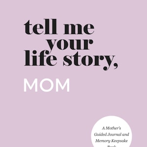 May include: A lavender-colored journal with the text "tell me your life story, MOM" in black and white. A white circle at the bottom right contains the text "A Mother's Guided Journal and Memory Keepsake Book."