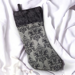 May include: A black velvet Christmas stocking with a gray and black damask pattern.