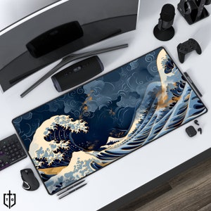 Puede incluir: Una alfombrilla de ratón grande azul y dorada con un diseño de ola japonesa. La ola está representada en un estilo tradicional con espuma blanca y detalles dorados.